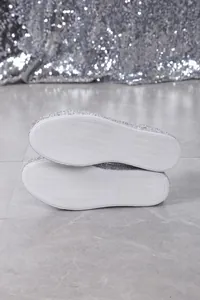Detail view showing the white non-slip outsole of silver sequin casual flat sneakers.
