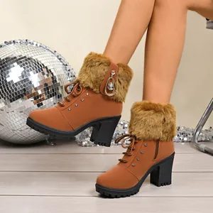 Fashionable brown high heel boots with faux fur trim and rhinestone details on a model