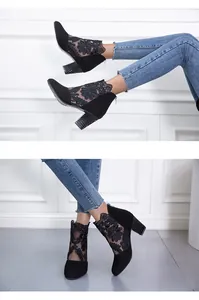 Detailed view of black lace mesh high-heeled ankle boots with rhinestone chunky heels