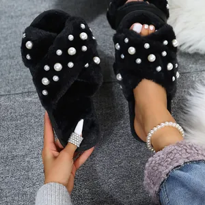 Detailed shot of black fuzzy cross-strap slippers with elegant pearl embellishments