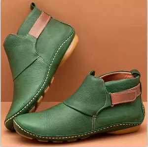 Detailansicht grüner Leder-Stiefeletten mit Klettverschluss und Kontrastnähten