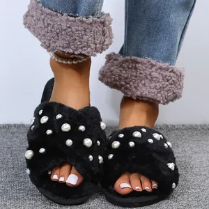 Close-up of black fuzzy cross-band slippers with pearl embellishments