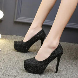 Detailopname van zwarte glitterpumps met plateauzool en hoge stilettohakken dames