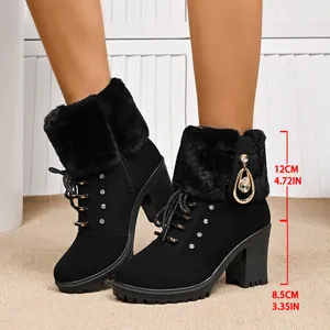 Detailed view of black faux fur winter boots with rhinestone pendant and chunky heels