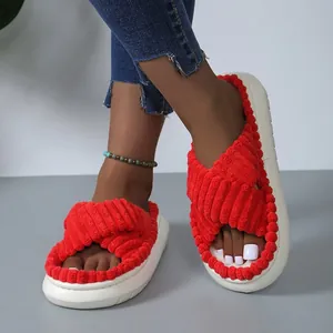 Dettaglio di pantofole rosse con zeppa in velluto a coste e design a fasce incrociate