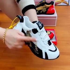 Detailansicht der goldenen Tiger-Stickerei auf weiß-schwarzen, atmungsaktiven Chunky Sneakers