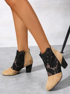 Close-up detail of women's floral lace mesh ankle boots with studded chunky high heels