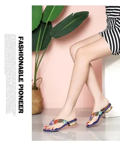 Close-up detail of bohemian rhinestone flip-flops on model for beach vacation style