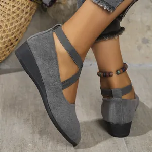 Detailed view of grey faux suede pointed toe wedge shoes with elastic cross straps
