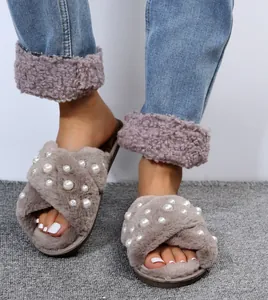 Close-up of fuzzy slippers with pearl decorations and cross-over straps