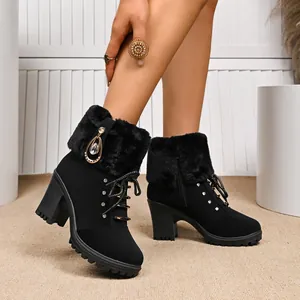 Close-up detail of black high-heeled boots featuring faux fur trim and rhinestones.
