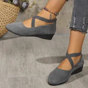 Close-up of stylish gray suede wedge shoes featuring elastic crisscross ankle straps