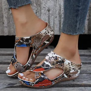 Detail of women's wedge sandals featuring vibrant snake print and elegant side cutouts.