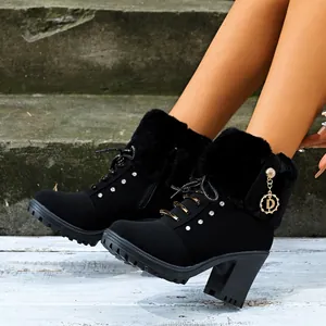 Close-up of black high-heeled boots with faux fur trim and stylish rhinestone details.