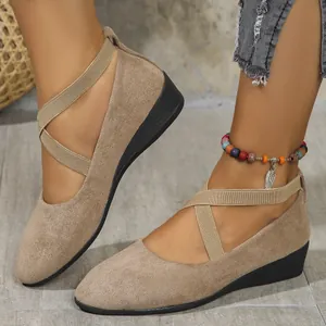 Detailed close-up of khaki suede wedge flats featuring stylish elastic cross straps for women