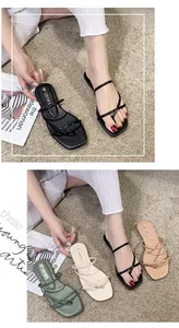 Dettaglio di eleganti sandali bassi infradito con cinturini colorati estivi per donna