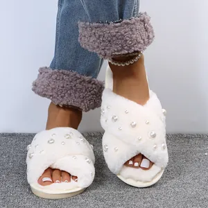 Close-up view of elegant white fuzzy cross-band slippers decorated with pearls