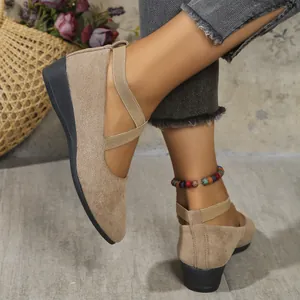 Detail view of khaki suede pointed-toe wedge shoes featuring stylish cross elastic straps