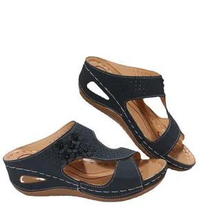 Elegant navy blue platform wedge sandals with floral accents and laser-cut details.