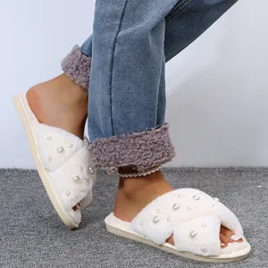 Detailed shot of white faux fur cross-strap slippers embellished with elegant pearls