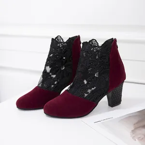 Detailed view of burgundy suede ankle boots with black floral lace mesh and chunky heels.