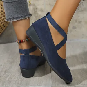 Close-up of navy blue suede wedge shoes with elegant elastic cross-straps detail