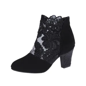 Detailed view of women's black lace mesh ankle boots with textured chunky heels.