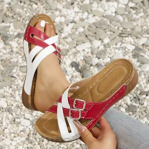 Detail view of red and white cross strap wedge sandals for women with buckle closure