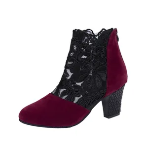 Macro detail of elegant burgundy suede and black floral lace mesh on a chunky heel boot