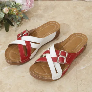 Detailed view of red and white cross-strap wedge sandals with stylish silver buckles