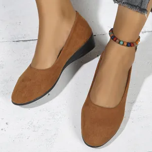 Macro detail view of brown suede women's wedge shoes with a stylish colorful beaded anklet