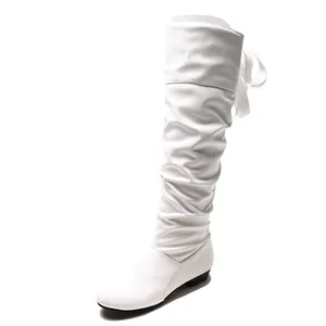Vista detallada de botas altas blancas fruncidas con un elegante detalle de lazo posterior