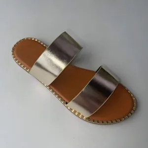 Close-up of women's metallic double strap flat sandals with stud detail