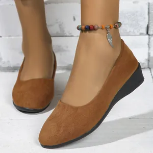Detailed close-up view of brown suede wedge pumps with a comfortable low heel design.