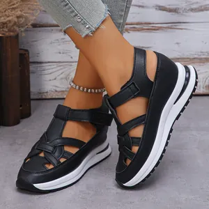 Close-up detail of women's black platform Roman sandals with Velcro straps and hollow-out design