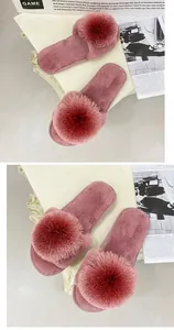 Vue rapprochée d'élégantes pantoufles en fausse fourrure rose avec grand pompon moelleux