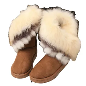 Bottes de neige d'hiver en faux daim marron avec bordure en fausse fourrure crème et semelle plate.