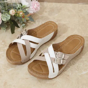 Elegant women's wedge sandals with white cross straps and adjustable metal buckles
