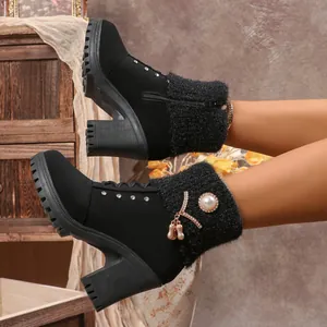 Detail of black high-heeled boots with faux fur trim and pearl rhinestone accents