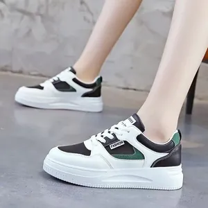 Detailansicht stilvoller Damen-Sneaker in Weiß mit schwarz-grünen Akzenten und dicker Sohle