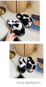 Dettaglio del motivo muccato e della morbida consistenza in peluche delle ciabatte.