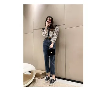 Full-body view of a model wearing casual rhinestone bow loafers with denim jeans.
