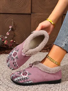 Detail of purple embroidered winter boots with warm fur lining and floral patterns