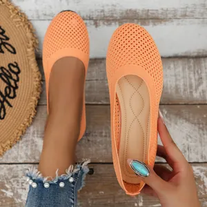 Orange breathable knit round-toe flats for women, lightweight casual slip-on shoes.