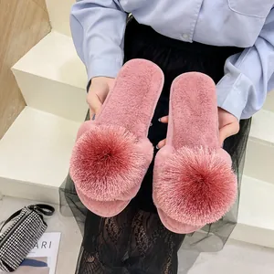 Pantoufles roses en peluche confortables avec un gros pompon décoratif pour la maison