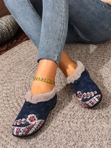 Close-up of ethnic embroidered cotton shoes with warm fur lining on a braided rug