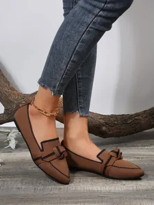 Detail shot of breathable brown fly-knit pointed-toe flat shoes with bow decor