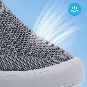 Gros plan du tissu fly-knit respirant sur des baskets grises sans lacets pour hommes.