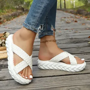Vista dettagliata dei sandali platform intrecciati bianchi da donna su un sentiero