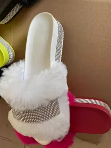 Detailed view of white faux fur slides with shimmering rhinestone bands on platform sole